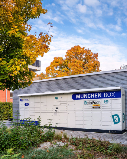 Aufnahme einer München Box Paketstation vor einem Wohnhaus. Viele Fächer unterschiedlicher Größe sind zu sehen.