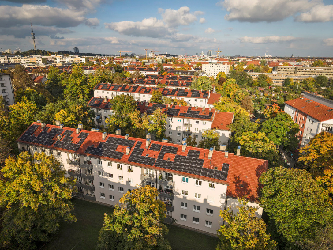 Drohnenaufnahme des Wohnkomplexes Max 2 mit Fokus auf die Photovoltaikanlagen auf den Dächern.