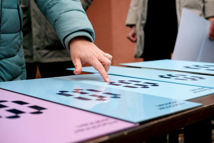 Eine Hand zeigt auf Schilder mit Münchner Wohnen Logo.