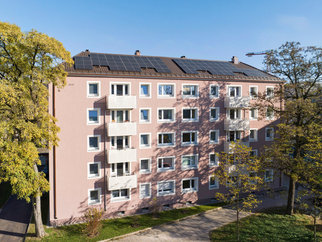 Hausansicht Agilolfingerstraße auf der Balkone und die Photovoltaikanlage auf dem Dach zu sehen sind.