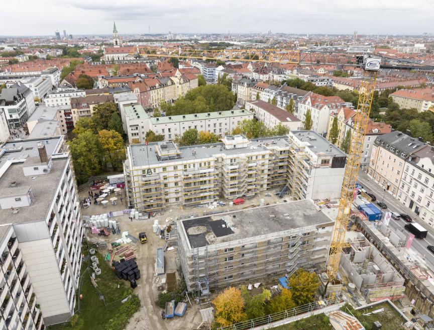 Luftbildaufnahme der Baustelle an der Plinganserstraße. Zu sehen ist wie die neuen Gebäuderiegel im dichten städtischen Bereich entstehen.